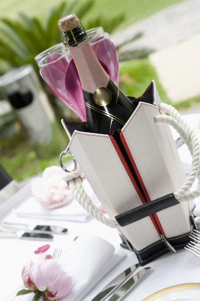 Garrafa de champanhe e copos na mesa de restaurante vestido — Fotografia de Stock