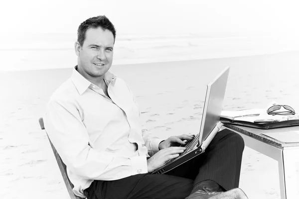 Бизнесмен с офисом на пляже — стоковое фото
