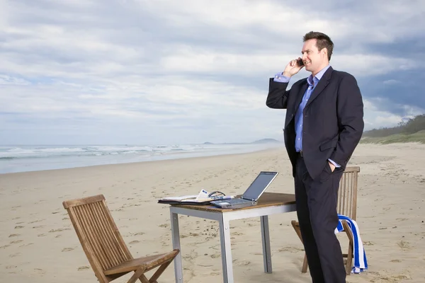 Бизнесмен с офисом на пляже — стоковое фото
