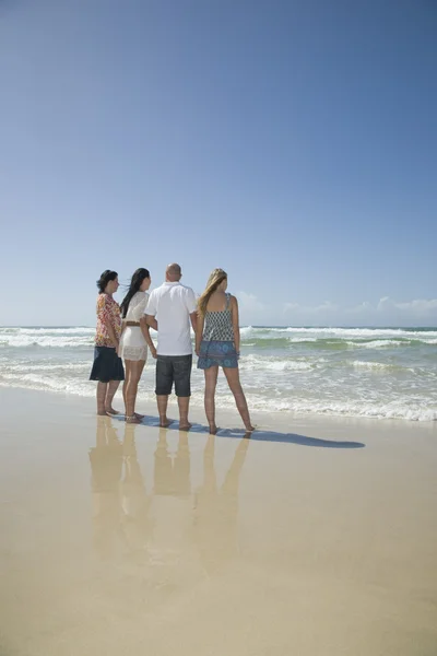Familia cogida de la mano mirando hacia fuera para surfear — Foto de Stock