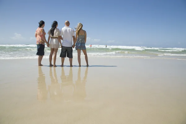 Familie hält Händchen und schaut zum Surfen — Stockfoto