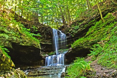 Waterfall in green forest, Michigan USA clipart