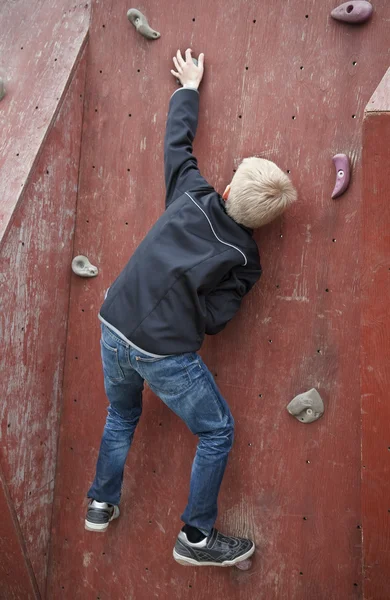Junge klettert eine Wand hoch — Stockfoto