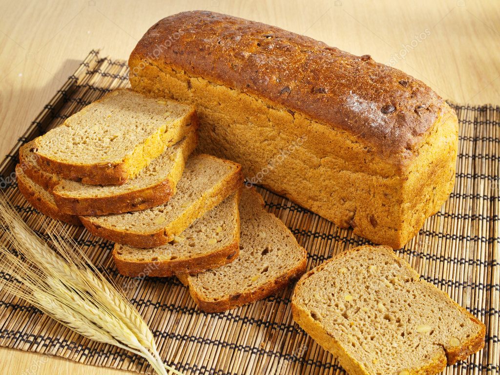 Freshly baked bread with soybeans and wheat on table — Stock Photo