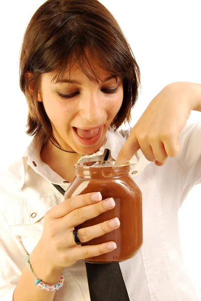 Menina coloca o dedo no frasco de chocolate — Fotografia de Stock