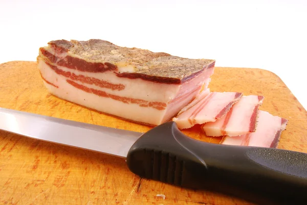 Nůž s plátky slaniny na prkénko připraven být cooke — Stock fotografie