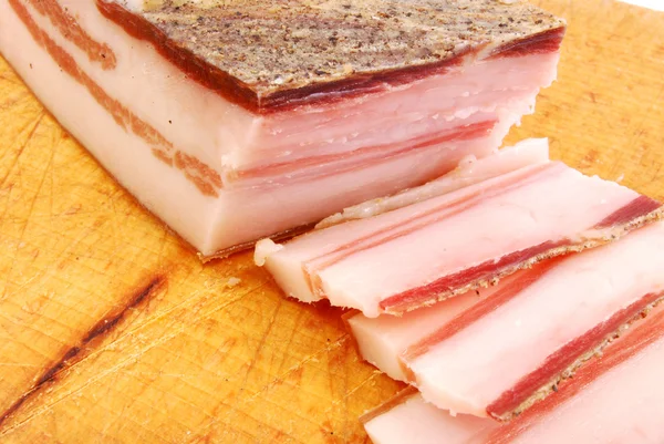 Slices of bacon on a chopping board ready for cooking — Stock Photo, Image