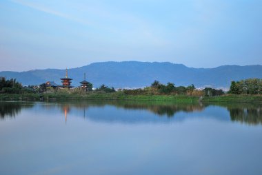 View of temple at the foot of mountain range clipart