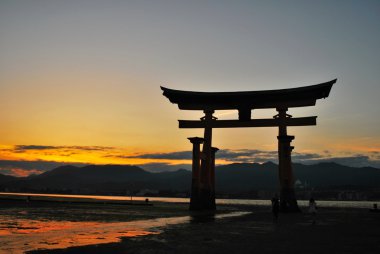 Torii gate of a temple during sunset clipart