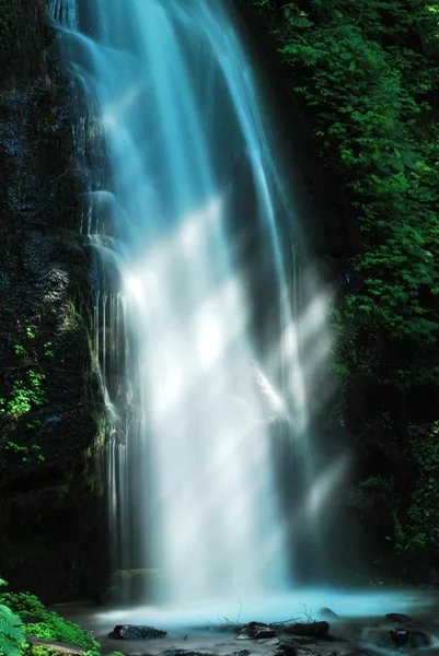 Величественный водопад с солнечными лучами — стоковое фото