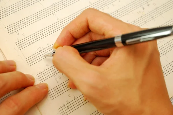 Composing music on old manuscript — 图库照片