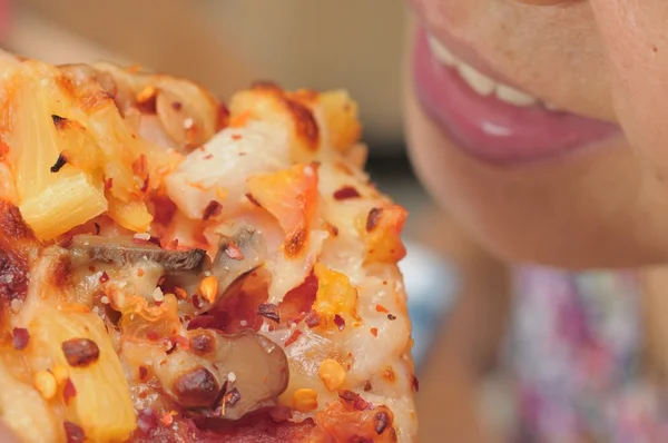 Aziatische vrouw eten van pizza — Stockfoto