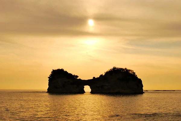 Heiterer Sonnenuntergang hinter einzigartig geformter Insel — Stockfoto