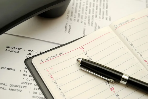 Telefonerna med utjämnat svart penna på planner — Stockfoto