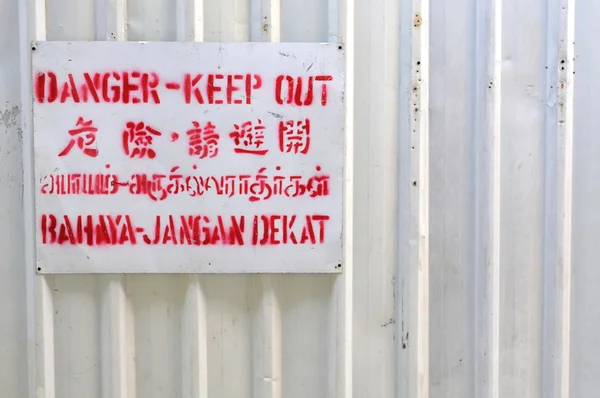 Danger signboard on white fence — Stock Photo, Image