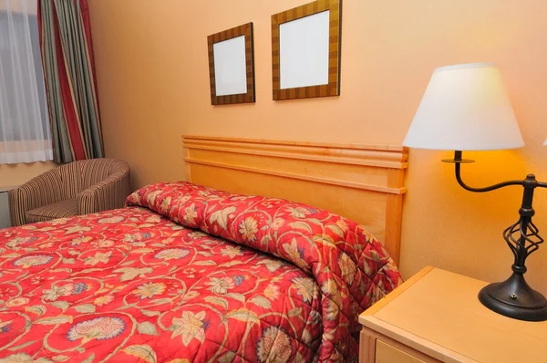 Primer plano de la cama roja del hotel — Foto de Stock