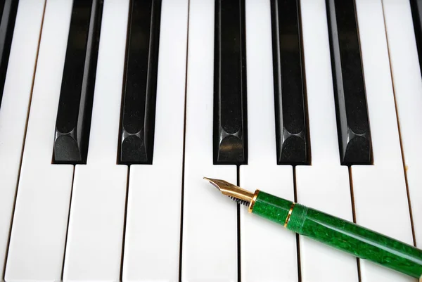 Teclado de piano con pluma —  Fotos de Stock