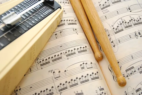 Music score, drum sticks and metronome