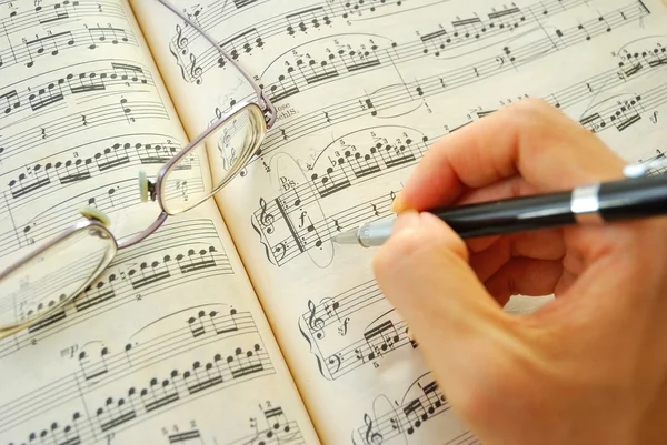 Escrevendo em uma partitura musical — Fotografia de Stock