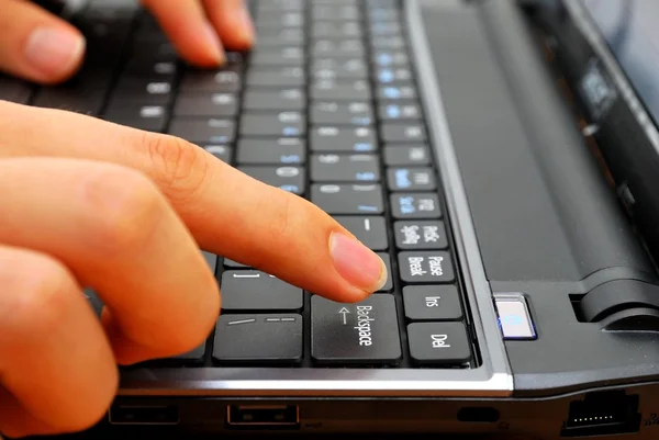 Palec natarczywy cofacz guzik na laptopie — Zdjęcie stockowe