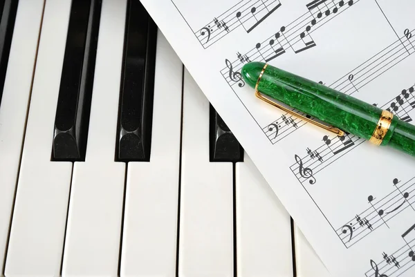 Teclado piano com partitura musical e caneta — Fotografia de Stock