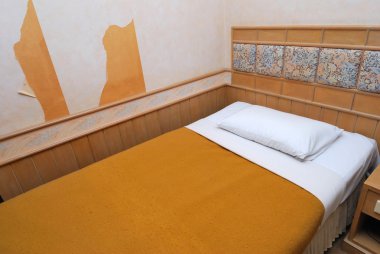 Single bed in modern hotel room clipart