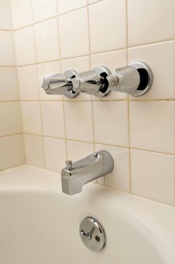 Side view of bathtub and water taps clipart