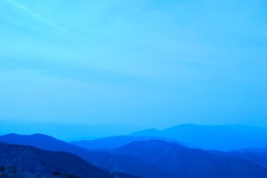 Mountain range covered in fog and mist clipart