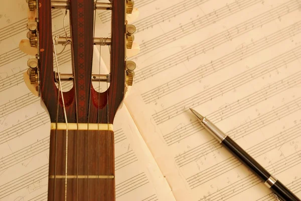 吉他与音乐手稿上的钢笔 — 图库照片