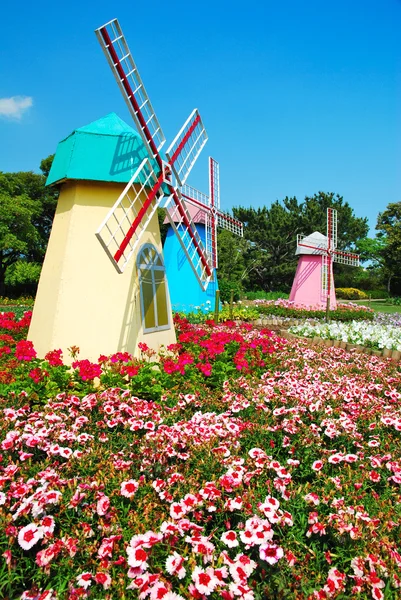 Три ветряные мельницы с полем цветов — стоковое фото