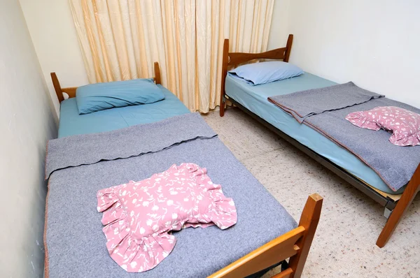 Camas individuais em quarto de motel simples — Fotografia de Stock