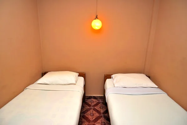 Två enkelsängar i mörka hotellrum — Stockfoto