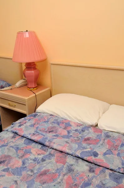 Удобная кровать с настольной лампой — стоковое фото