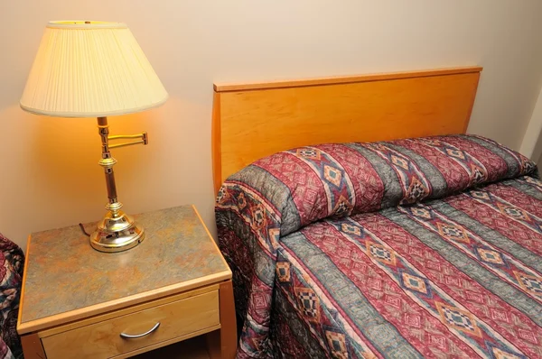 호텔 침대와 조명된 램프 — 스톡 사진