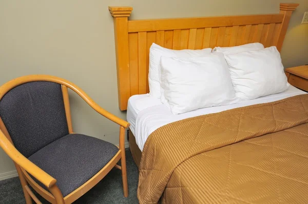 Quarto de hotel com cama e cadeira — Fotografia de Stock