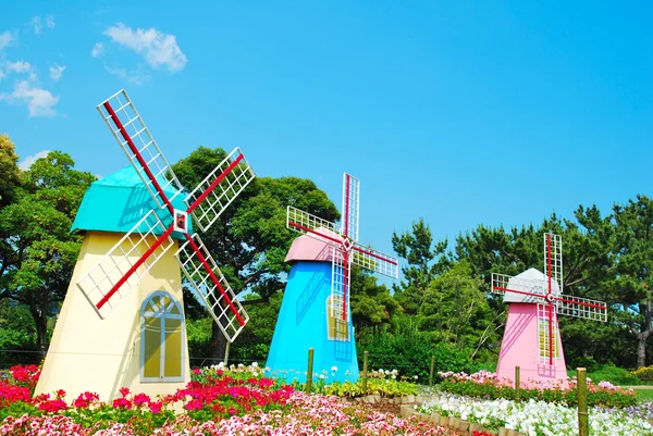 Три ветряные мельницы с полем цветов — стоковое фото
