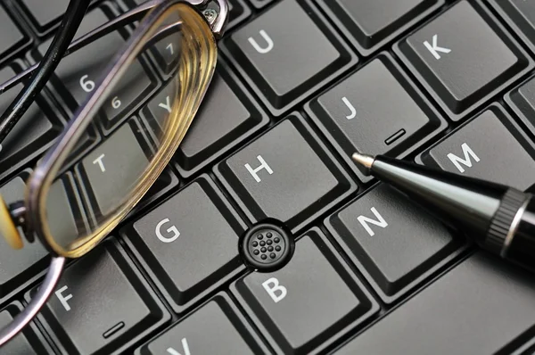 Teclado, óculos e caneta — Fotografia de Stock