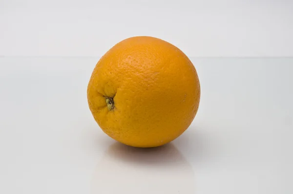 stock image A juicy orange with a piece of cellulite on a white background