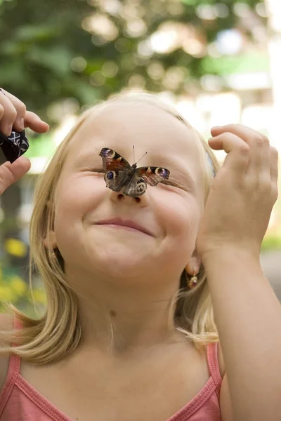 Girl with butterfly on nose — Stock Photo, Image