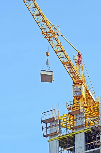Кран над зданием на строительной площадке — стоковое фото