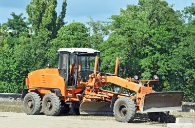 Grader on road construction site clipart