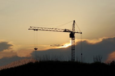 Tower crane at sunset clipart