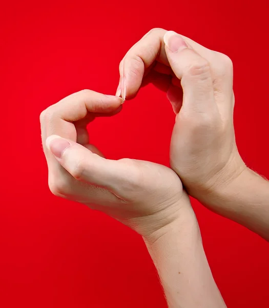 Mãos como coração no fundo vermelho — Fotografia de Stock