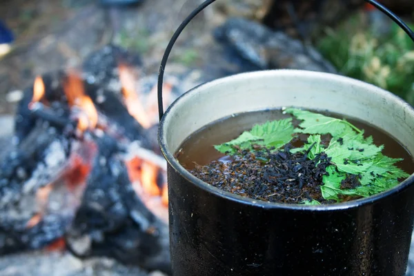 stock image Teapot with a liquid against fire