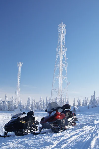 Sneeuwscooters en communicatieapparatuur in bos Stockfoto