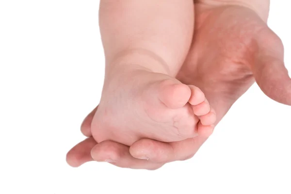 Kinderen voet en volwassen hand — Stockfoto