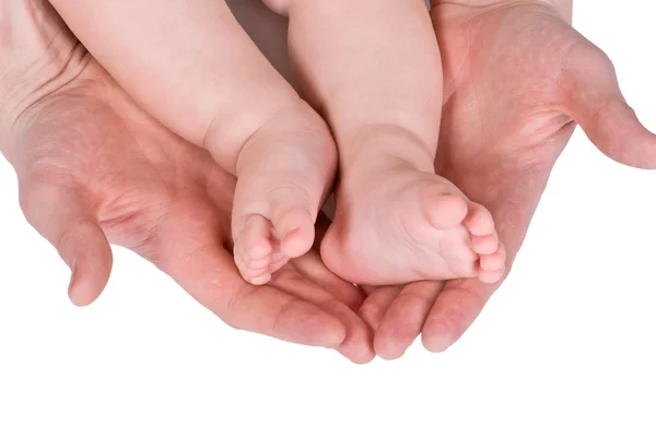 Barn fot och vuxen hand — Stockfoto