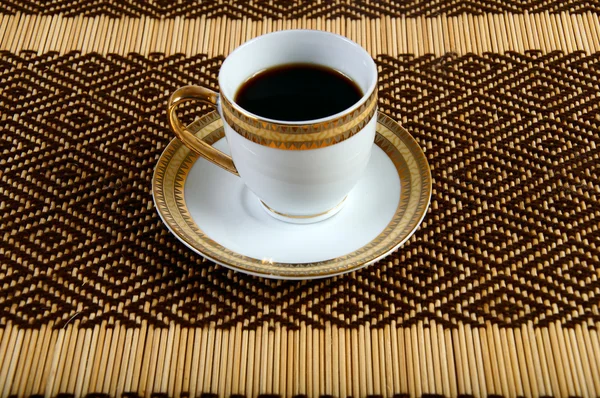 Cup of coffee on the tablecloth — Stock Photo, Image