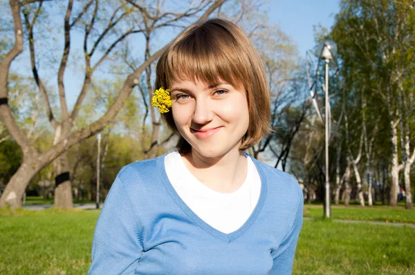 Lachende meisje zit in het park — Stockfoto
