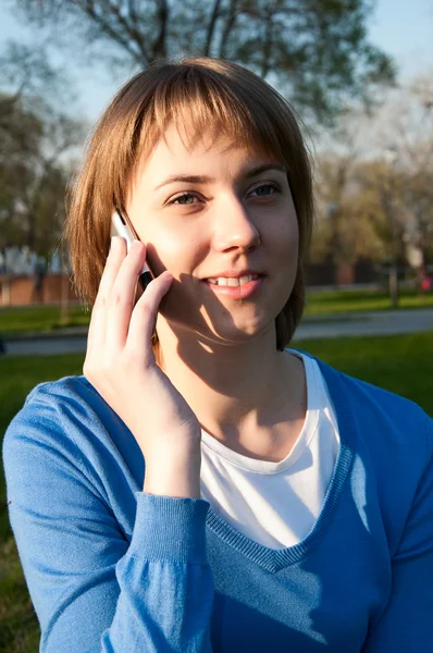 Dziewczyna rozmawia z komórki w parku — Zdjęcie stockowe